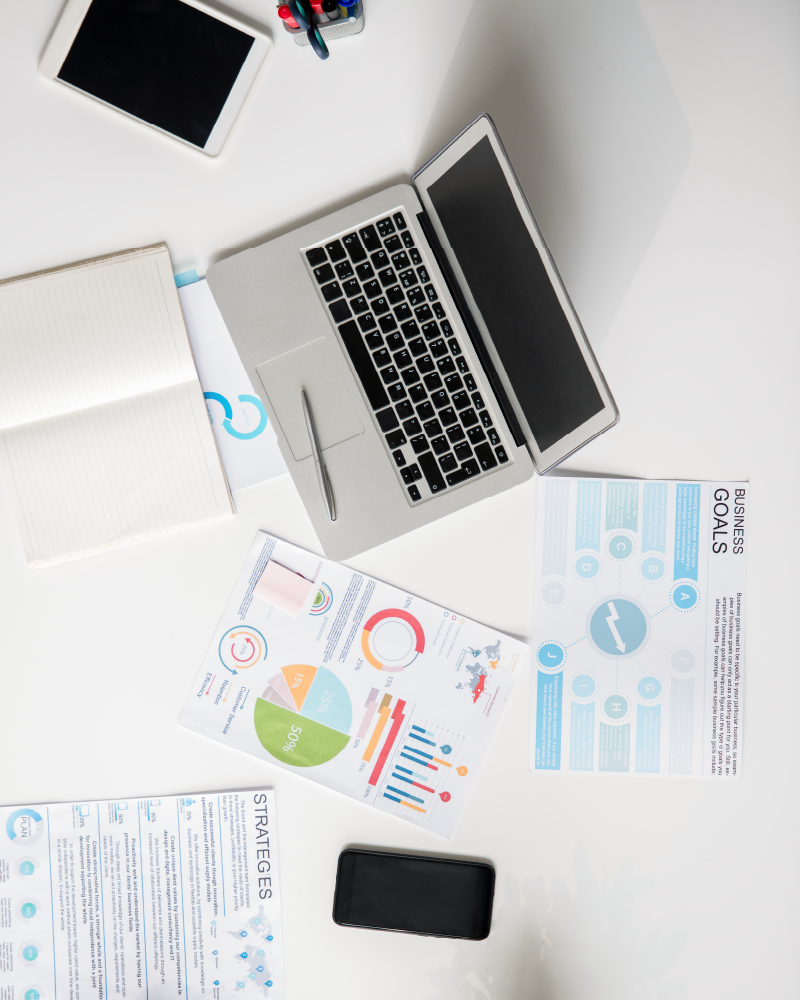 overhead photo of laptop and charts